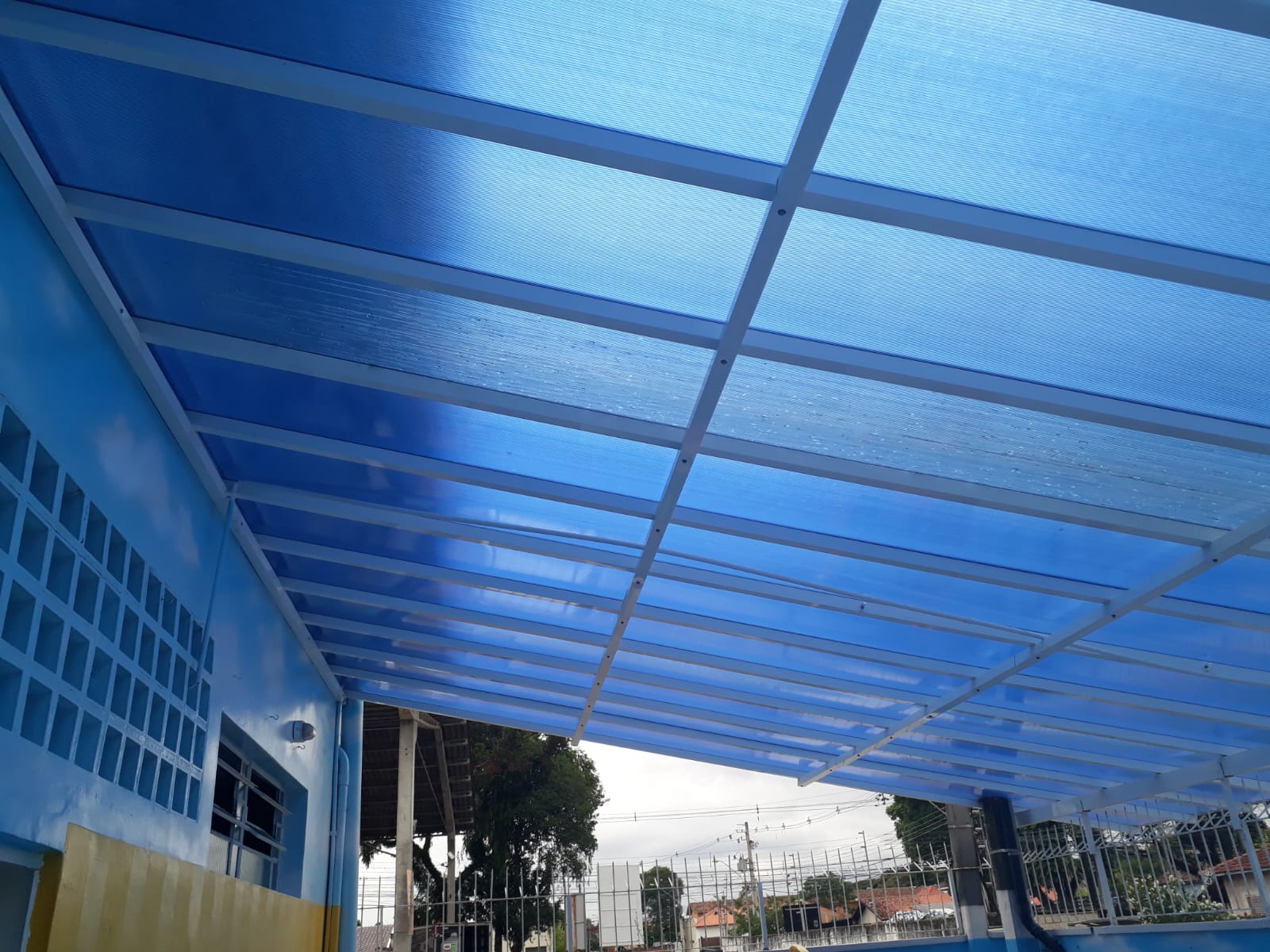 Cobertura metálica com telhas translúcidas azuis instaladas