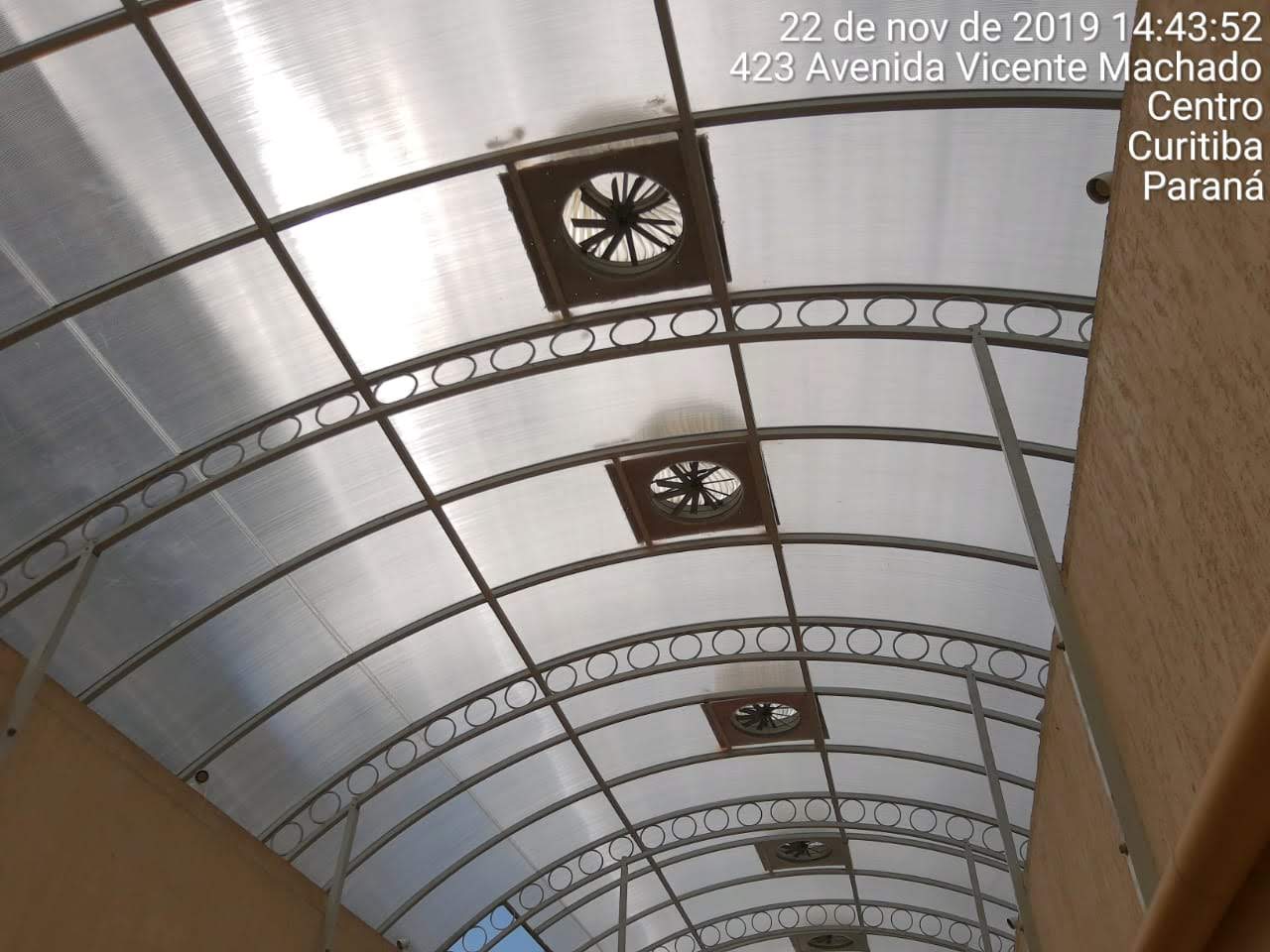 Cobertura metálica curva com círculos decorativos e exaustores