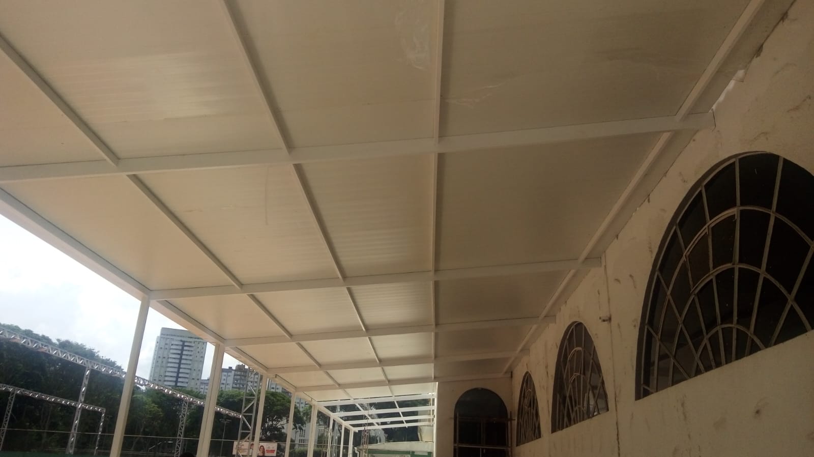 Estrutura interna de cobertura metálica com perfis brancos